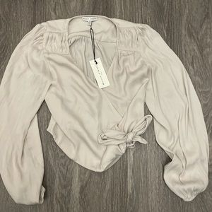 Cream blouse with tie in front. Brand new with tags still on it.